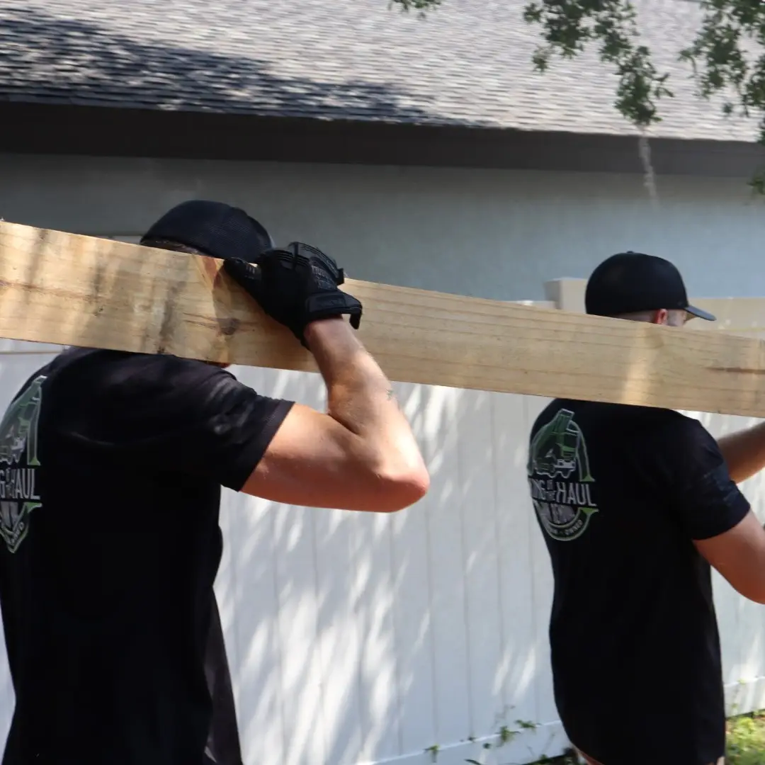 Two Men Carrying Plank